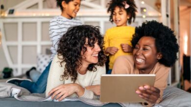 A family smiling and looking at a tablet.