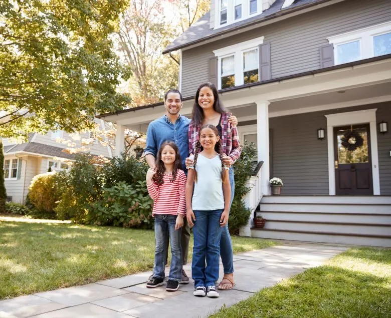 Portrait of a family standing in front of their home.